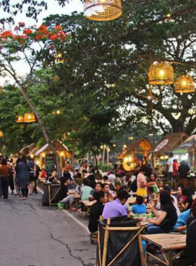 This image shows Ayutthaya Night Market, a vibrant evening destination featuring a mix of street food and handcrafted items. The image captures the lively decor, stalls with colorful displays, and visitors enjoying authentic Thai dishes like pad Thai and coconut ice cream.