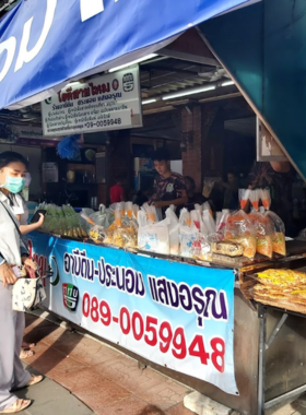 This image shows Roti Sai Mai Abeedeen-Pranom Sangaroon, a popular dessert shop in Ayutthaya. It highlights their signature pandan wraps filled with colorful cotton candy, a unique and fragrant Thai treat loved by locals and tourists.