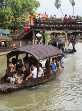 This image shows the Khlong Sra Bua Floating Market with vibrant boats and cultural performances. The market highlights local crafts, food, and traditional Thai storytelling on boats.