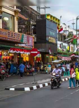 This image shows the lively Malioboro Street in Yogyakarta, filled with vibrant food stalls offering local delicacies like gudeg, fried chicken, sweet martabak, and es dawet. The bustling night market atmosphere captures the essence of Yogyakarta’s rich culinary heritage, making it a must-visit for street food lovers. The colorful stalls, street scenes, and budget-friendly options make it a perfect spot for those looking to indulge in authentic Indonesian flavors while exploring the city's vibrant culture.