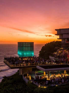 This image shows the exclusive beachfront club experience at Savaya Bali, offering stunning ocean views, an infinity pool, and top-tier DJ performances. It captures guests lounging by the pool and enjoying luxury in one of Bali's most picturesque locations.