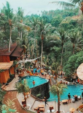 This image shows the scenic beauty of D'tukad River Club, a riverside venue in Bali with breathtaking views and a unique cliffside swing. Guests are enjoying food, drinks, and the natural surroundings while experiencing one of Bali’s most Instagrammable spots.