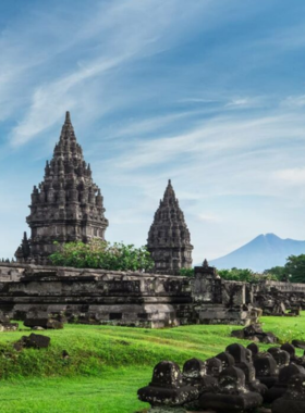 This image shows the ancient Borobudur Temple in Yogyakarta, Java, surrounded by lush green landscapes. The majestic Buddhist temple, one of the world’s largest and most iconic, is adorned with intricate stone carvings and statues. Nearby, the Prambanan Temple, a Hindu temple complex, stands tall with its towering spires. Yogyakarta is renowned for its rich cultural heritage and historical landmarks, offering visitors a deep dive into Indonesia’s ancient religious and architectural legacy.