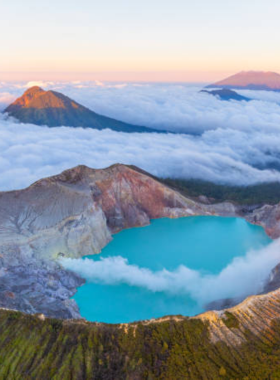 This image shows the striking blue flames of Kawah Ijen, a volcano in East Java. The natural phenomenon is caused by the combustion of sulfur at night, creating a mesmerizing and surreal glow. The crater lake, with its turquoise waters, adds to the surreal beauty of the landscape. The challenging trek to the top of the volcano provides visitors with a unique adventure, while the sulfur miners offer a glimpse into the area's industrial activity. It’s an unforgettable experience for nature and adventure enthusiasts.