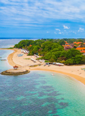 sanur-beach-calm-waters-sunrise This image shows a serene and peaceful view of Sanur Beach in Bali, with calm, shallow waters perfect for swimming. The image captures the beautiful sunrise over the horizon, highlighting the tranquil vibe of the beach. It’s a great spot for relaxation and a leisurely stroll, away from the crowds, offering a perfect setting to enjoy nature and the scenic beauty of the coastline.