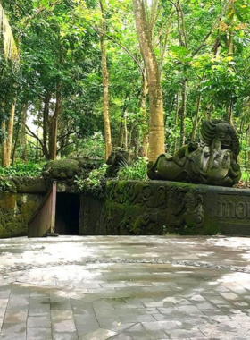 sacred-monkey-forest-ubud This image shows the Sacred Monkey Forest Sanctuary in Ubud, Bali, where visitors can walk through lush greenery and interact with long-tailed macaques. The image highlights the peaceful trails and ancient temple ruins surrounded by vibrant tropical plants. The sanctuary provides a calming experience, allowing visitors to get close to nature and observe the playful monkeys in their natural habitat.