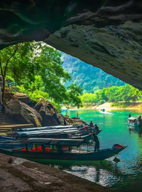 Phong Nha Cave Adventure This image shows a boat gliding through the dark and enchanting pathways of Phong Nha Cave. The limestone formations and underground rivers create a magical scene, highlighting the natural wonder of this UNESCO World Heritage Site, inviting visitors to marvel at the stunning beauty of Vietnam’s caves.