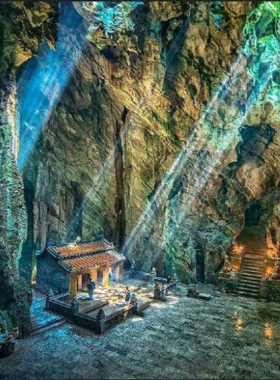 Hiking Marble Mountains in Da Nang This image shows a traveler hiking up the Marble Mountains in Da Nang, with expansive views of the surrounding landscape and ocean. The limestone hills are dotted with ancient Buddhist shrines, offering a spiritual and adventurous experience amid breathtaking natural beauty.