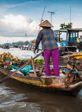 Floating Market in Vietnam This image shows colorful boats loaded with fresh produce, spices, and traditional Vietnamese dishes at a bustling floating market. The vibrant scene captures the essence of Vietnam’s culinary culture, offering a unique opportunity to try local flavors while enjoying the lively atmosphere of the waterways.