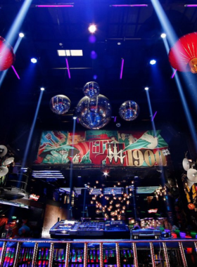 This image shows 1900 Le Theatre nightclub in Hanoi, housed in a historic French opera house. The photo depicts the mix of grand architecture, vibrant lighting, and a trendy crowd dancing to live DJ performances.