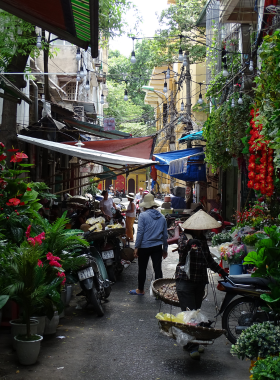 This image shows that the Hanoi Old Quarter is full of vibrant, narrow streets filled with colonial buildings, busy street vendors, and local shops. The hustle and bustle of daily life create a lively atmosphere where visitors can explore unique crafts, taste street food, and experience traditional Vietnamese culture.