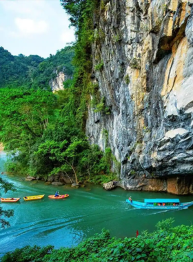 This image shows the awe-inspiring limestone caves of Phong Nha-Ke Bang National Park, with stunning stalactites, an underground river, and a boat gliding through the cave. It illustrates the beauty and grandeur of this UNESCO World Heritage Site, offering a glimpse of its mysterious caves and lush surrounding forests that attract adventurers and photographers.