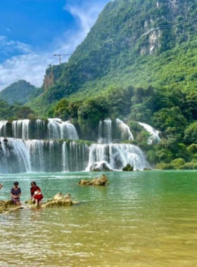 This image shows the tranquil Ba Be Lake surrounded by dense forest and dramatic limestone cliffs. A small boat floats peacefully on the water, reflecting the serene beauty of the park, which is known for its biodiversity and breathtaking landscapes.