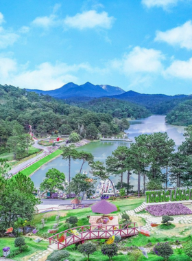 This image shows the picturesque Valley of Love in Da Lat, with colorful flower gardens, pine forests, and a serene lake. A small boat floats gently on the water, surrounded by blooming flowers, capturing the romantic and peaceful vibe of this scenic destination.