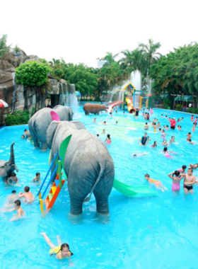 This image shows the vibrant Dam Sen Water Park with colorful water slides spiraling into clear pools below. Families and children are seen enjoying the wave pool, while others relax in shaded areas. The bright and lively atmosphere is perfect for a day of fun and cooling off under the sun. The variety of attractions visible in the image highlights the park's appeal to visitors of all ages.