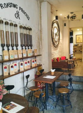 This image shows a cozy corner of Saigon Coffee Roastery, with a steaming cup of Vietnamese coffee served alongside a small pastry. The rustic decor and relaxed setting create the perfect ambiance for coffee enthusiasts to unwind.