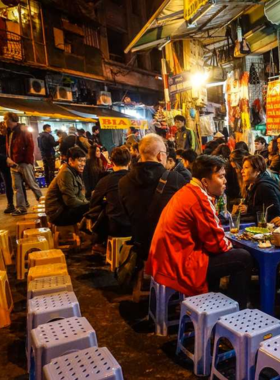 This image shows the vibrant and bustling Co Giang Street, lined with food stalls offering Vietnamese snacks like goi cuon and bun bo Hue. The lively atmosphere, with locals and tourists enjoying their meals on plastic stools, captures the heart of Saigon’s street food scene.