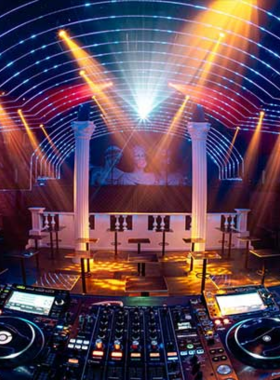 This image shows Republic Club, a neon-lit nightclub in Ho Chi Minh City. The dance floor is packed with people moving to high-energy music under vibrant strobe lights. The DJ is playing upbeat tracks, and the room is filled with excitement. Tables are lined with drinks, and the crowd is a mix of locals and tourists. The club’s lively atmosphere and electric vibe make it an unforgettable destination for those seeking a thrilling nightlife experience.