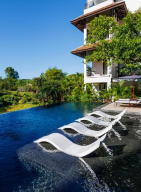 This image shows Anhill Boutique, a peaceful boutique hotel surrounded by lush greenery in Hue. The picture highlights its tranquil garden-view rooms, an inviting swimming pool, and an outdoor seating area perfect for relaxation. The on-site spa offers rejuvenating treatments, while the restaurant serves a variety of local and international dishes. Its serene and intimate atmosphere makes it a favorite for couples and solo travelers looking for privacy and relaxation.