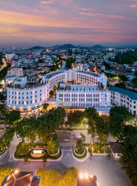 This image shows the luxurious Silk Path Grand Hue Hotel, known for its opulent interiors and exceptional services. The photo showcases its grand architecture, a sparkling outdoor pool, and a fine-dining restaurant offering gourmet experiences. The hotel’s wellness center provides a range of relaxing treatments, while the event spaces are perfect for weddings and conferences. Its elegant design and premium amenities make it a preferred choice for travelers seeking indulgence in Hue.