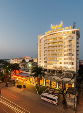 This image shows Muong Thanh Holiday Hue Hotel, a riverside hotel offering stunning views of the Perfume River. The photo highlights its modern exterior, comfortable rooms with large windows, and an outdoor dining area overlooking the river. Guests can relax with traditional Vietnamese breakfasts and spa services. The peaceful setting and affordable luxury make it a wonderful option for travelers wanting a scenic and comfortable stay in Hue.