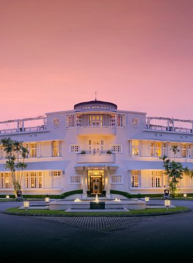 This image shows Azerai La Residence Hue, a colonial-style luxury boutique hotel on the banks of the Perfume River. The photo features its art deco architecture, a riverside pool with sun loungers, and lush gardens. Guests can enjoy elegant rooms, spa services, and fine dining experiences. Its unique blend of history, charm, and modern amenities makes it a standout choice for those who want a sophisticated stay in Hue.