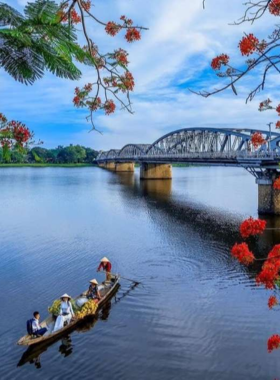 This image shows kayakers paddling along the calm waters of the Perfume River in Hue, Vietnam. The river is surrounded by iconic landmarks, lush greenery, and traditional Vietnamese architecture. The tranquil scene highlights the combination of nature and culture, offering visitors a unique way to explore Hue’s beauty while enjoying a peaceful kayaking experience.