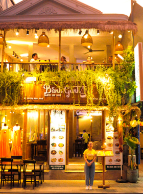 This image shows Bánh Gánh Restaurant, a classic Hue eatery where you can enjoy home-style Vietnamese meals. The welcoming vibe of the restaurant is captured in the cozy dining area, with plates of fresh spring rolls on the table. The generous portions and traditional dishes make it a popular spot for both breakfast and dinner. The friendly atmosphere and the authentic flavors of Hue are what make this place a must-visit in the city.