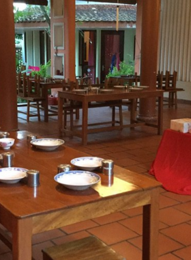 This image shows Peaceful Bamboo Family Tea House, a serene spot in Hue where you can enjoy calming tea in a beautiful setting. The picture captures a cozy table set for tea, surrounded by lush greenery and a peaceful ambiance. It’s an ideal location for those seeking tranquility, offering a retreat from the busy streets of Hue. Whether you're spending time with family or enjoying a quiet moment alone, this tea house offers a peaceful atmosphere to relax and recharge.