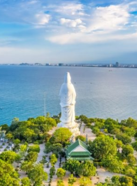 This image shows a scenic drive along the winding roads of the Son Tra Peninsula in Da Nang. The view captures lush forests on one side and stunning views of the ocean on the other. The motorbike ride offers a glimpse of the massive Lady Buddha statue at Linh Ung Pagoda, standing tall as a symbol of protection. The peaceful and serene surroundings make this an ideal getaway for nature lovers and adventure seekers.