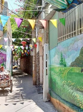 This image shows the vibrant murals at Fresco Village in Da Nang, an artistic neighborhood. Colorful paintings adorn the walls, showcasing local culture, folklore, and whimsical art by Vietnamese artists. The murals have transformed the quiet alley into an open-air art gallery. Visitors can be seen strolling through, admiring the artwork. The bright colors and creative expressions make this a unique spot for photo opportunities and cultural appreciation.