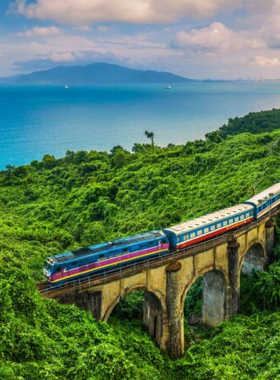 This image shows the stunning views from the Hai Van Pass, a winding mountain road that offers spectacular vistas of lush jungles and the coastline. The road twists through the misty peaks, and visitors can be seen riding motorbikes, taking in the breathtaking scenery. The image captures the exhilarating adventure of traveling this iconic pass, with its dramatic landscape and natural beauty as the highlight of the journey.