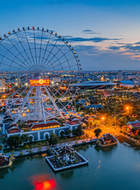 Alt Text: This image shows the Sun Wheel at Asia Park in Da Nang, offering a panoramic view of the city. The iconic wheel stands tall against the evening sky, illuminated with vibrant lights. The park’s amusement rides and cultural performances add to the lively atmosphere. Visitors can be seen enjoying the view from the top or participating in the exciting rides. The image captures the fun and excitement of the park, making it a must-visit destination.