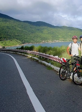 This image shows a group of mountain bikers riding through the trails of Son Tra Peninsula in Da Nang, Vietnam. The rugged terrain and scenic views make it an exciting adventure for biking enthusiasts. The cyclists are seen navigating through dense jungle trails, with lush greenery surrounding them. The image captures the thrill and challenge of mountain biking, with the beautiful natural scenery of Son Tra serving as a perfect backdrop for outdoor adventurers.