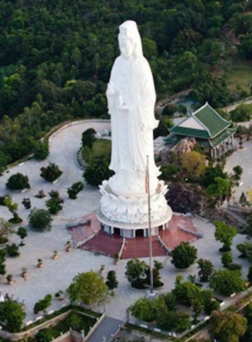 This image shows the Lady Buddha statue on Monkey Mountain in Da Nang, Vietnam. The statue, standing tall at 67 meters, overlooks the city and coastline, offering breathtaking views. The image captures the serene atmosphere surrounding the statue, with visitors admiring the view and the peaceful environment. The lush greenery and stunning vistas make it a perfect spot for sightseeing and spiritual reflection, offering visitors both beauty and peace at the top of Monkey Mountain.