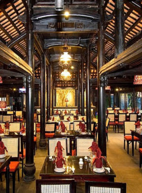 This image shows Lam Vien Restaurant in Da Nang, Vietnam, a beautiful dining space surrounded by lush greenery and elegant interiors. The restaurant offers a mix of traditional Vietnamese and international cuisines, making it a popular choice for both tourists and locals. The serene ambiance, decorated with plants and warm lighting, creates a perfect setting for romantic dinners or peaceful family meals.