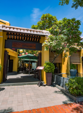 This image shows Madame Lan, a charming riverside restaurant in Da Nang, Vietnam. The photo captures the inviting outdoor seating area surrounded by greenery and soft lighting. Diners enjoy authentic Vietnamese dishes like pho, grilled meats, and seafood. The relaxed atmosphere, coupled with scenic views of the Han River, makes it a favorite dining destination for both locals and visitors.