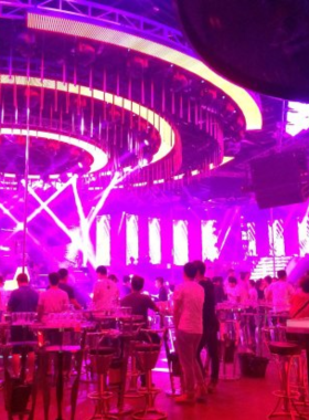 This image shows On the Radio Bar in Da Nang, a cozy venue with live music performances. The bar features a stage with musicians playing instruments, surrounded by a friendly crowd. The dim lighting, comfortable seating, and vibrant decor create a welcoming and lively atmosphere. Guests are seen clapping and enjoying the rhythm of the music, making this bar a favorite for those seeking an authentic and relaxed nightlife experience.