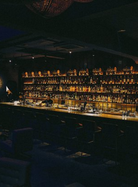 This image shows Tê Bar, an intimate cocktail bar in Da Nang known for its Vietnamese-inspired drinks. The ambiance is cozy, featuring warm lighting, artistic decor, and bartenders crafting intricate cocktails. Guests are seated at small tables, engaged in conversations while sipping on vibrant, beautifully presented drinks. This bar stands out for its creative mixology and peaceful vibe, offering a unique experience for those who enjoy quality cocktails and quiet moments.