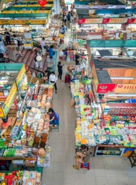 This image shows the bustling atmosphere of Han Market in Da Nang, with vibrant stalls selling fresh produce, souvenirs, and traditional snacks. The image captures the lively energy of the market, where locals and tourists interact and bargain. It’s a great place to experience Da Nang’s daily life and taste local delicacies like dried squid and rice cakes. The friendly vendors and colorful displays create an authentic cultural experience for visitors looking to shop and explore the city.