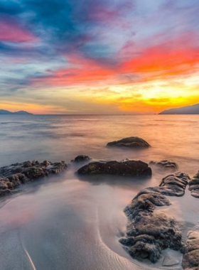 This image shows that Nam O Beach is a peaceful spot in Da Nang with a fishing village atmosphere. The beach is not only a beautiful location for landscape photography but also offers insights into local life with fishermen working along the shore. The unique rock formations and tranquil setting provide plenty of opportunities to capture both natural beauty and cultural scenes, making it an ideal spot for photographers interested in coastal life.