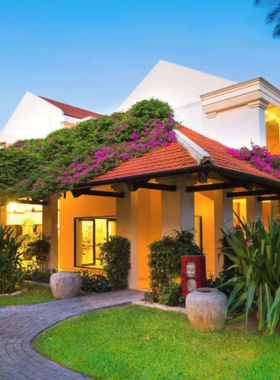 This image shows the beautiful Anantara Hoi An Resort, located along the scenic Thu Bon River. The resort features traditional Vietnamese architecture with lush greenery and tranquil surroundings. The spacious rooms have private balconies offering picturesque views, making it an ideal retreat. Guests can enjoy luxurious amenities like a swimming pool, spa, and yoga sessions while being minutes from Hoi An's vibrant Ancient Town. This serene and stylish environment perfectly blends culture with comfort.