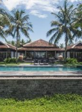 This image shows the ultra-luxurious Four Seasons Resort The Nam Hai, set along a pristine beachfront. The resort’s modern villas feature private pools surrounded by lush tropical landscapes. The eco-friendly design of the property reflects its commitment to sustainability, with organic gardens and energy-efficient practices. Guests can indulge in spa treatments, yoga, and cooking classes while enjoying direct access to a private beach. This peaceful haven combines style and sustainability seamlessly.