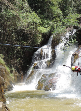 This image shows an adventurous tourist rock climbing on rugged cliffs during a Phat Tire Ventures tour in Hoi An. The climber is equipped with safety gear and is guided by an experienced instructor. In the background, lush greenery and a flowing river add to the scenic beauty of the location. This adventure combines physical challenge and stunning views, making it an exciting activity for outdoor enthusiasts visiting Hoi An.