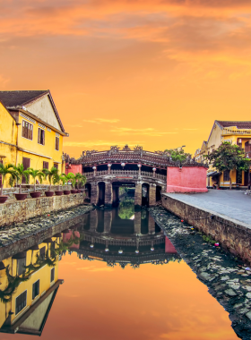 This image shows visitors participating in traditional Vietnamese crafts during the Hoi An Village Experience. The scene captures a local artisan teaching tourists how to weave bamboo baskets. In the background, lush green fields and wooden huts set the idyllic countryside vibe. Visitors are also seen engaging in activities like fishing and rice planting, immersing themselves in the village’s rich cultural heritage. This hands-on tour offers a warm and authentic glimpse into rural life in Hoi An.