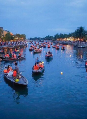 This image shows a serene boat ride on the Hoai River during the Hoi An Night Boat Tour. The boat is beautifully decorated with glowing lanterns, creating a magical ambiance. A visitor is seen releasing a floating lantern into the water, symbolizing good luck and wishes. The river reflects the vibrant colors of the lanterns, while the ancient town of Hoi An shines brightly in the background. This enchanting experience captures the romantic and cultural essence of Hoi An at night.