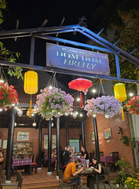 This image shows Firefly Garden Restaurant & Bar in Hoi An, offering a peaceful dining experience amidst lush greenery. With a beautiful outdoor seating area surrounded by trees and lanterns, Firefly Garden creates a tranquil escape from the busy streets. The restaurant’s menu features both Asian and Western dishes, and the crispy bánh xèo (Vietnamese pancakes) and white rose dumplings are particularly popular. A perfect place for a relaxing dinner or evening drink while enjoying the serene ambiance.