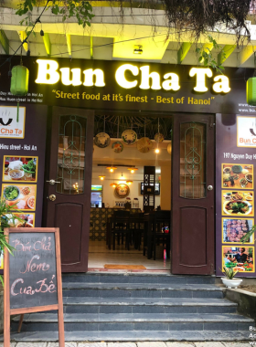 This image shows Bun Cha Ta Hoi An, a street food restaurant famous for serving authentic Hanoi-style bun cha. This no-frills eatery offers grilled pork with noodles and a savory dipping sauce, bringing a taste of Hanoi to Hoi An. The small setting and budget-friendly prices make it a favorite among both locals and tourists looking to experience traditional Vietnamese street food. If you're after quick and delicious bites, Bun Cha Ta is the place to go for an unforgettable street food experience.