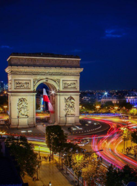 This image shows the famous Champs-Élysées Avenue leading up to the majestic Arc de Triomphe in Paris. The wide avenue is lined with trees, elegant shops, cafés, and theatres, making it a prime location for shopping and people-watching. The Arc de Triomphe stands proudly at the end of the avenue, commemorating France’s military victories. The view captures the grandeur of the area, showcasing the harmony of architecture, history, and culture that Paris is known for.