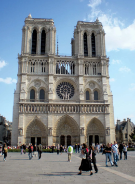 This image shows the majestic Notre-Dame Cathedral in Paris, with its gothic architecture and towering spires. The cathedral is a masterpiece of medieval design, featuring intricate sculptures, stained glass windows, and a beautifully detailed façade. Although the cathedral is under restoration after the fire, it still stands as one of Paris’ most iconic landmarks. The image captures the grandeur of the cathedral, with the surrounding gardens and the Seine River nearby, making it a peaceful and awe-inspiring location.